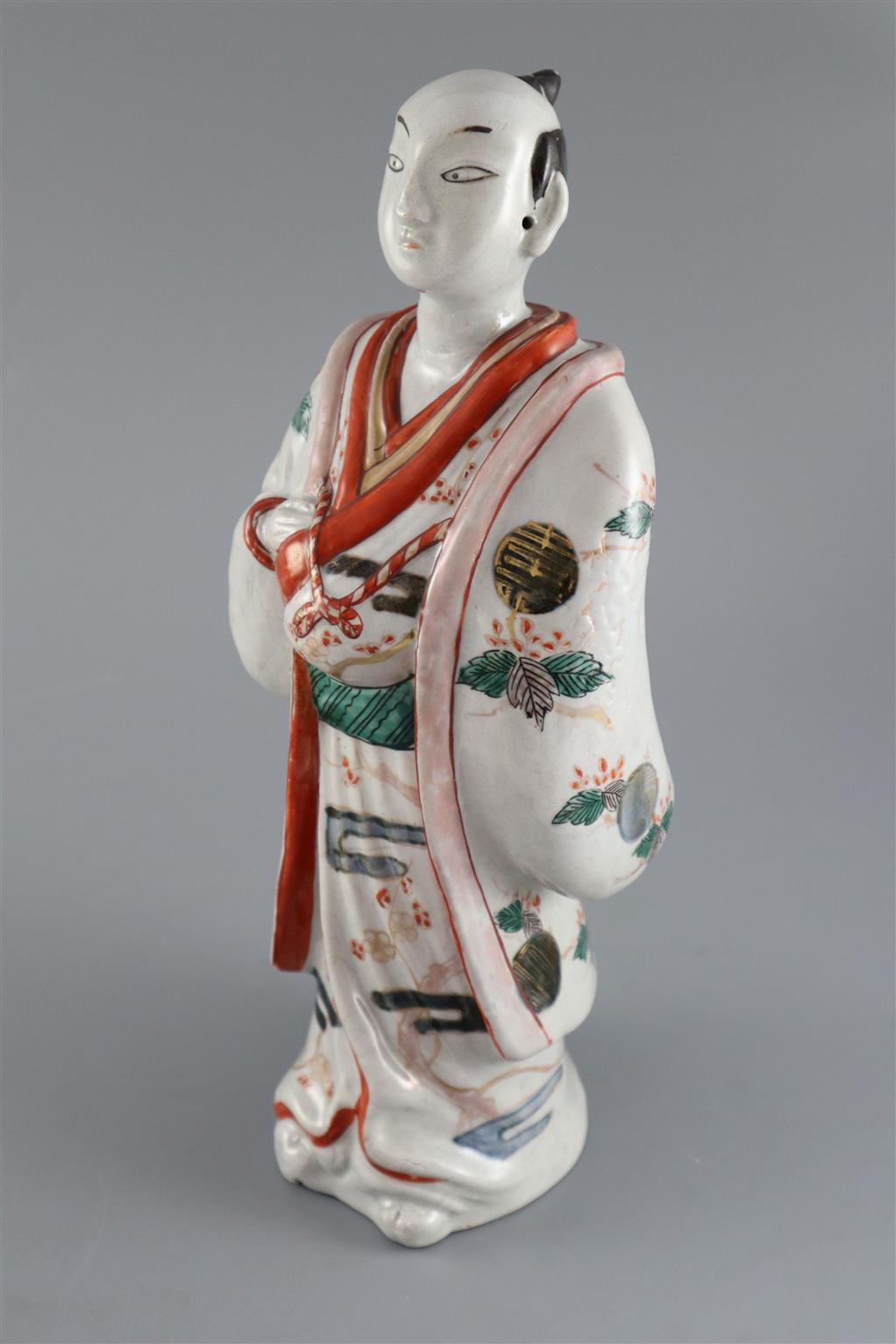 A Japanese porcelain figure of a man dressed in a kimono, Hizen, c.1690-1720, 31.5cm high